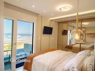 Quarto com vista para o mar e janela ampla.