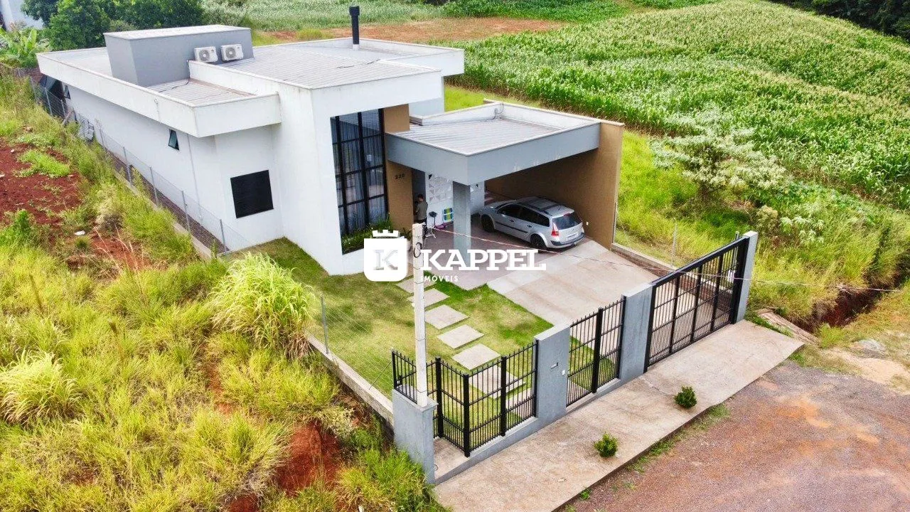 Fachada de uma casa moderna em Lajeado, Brasil, com área de garagem coberta e jardim ao redor.