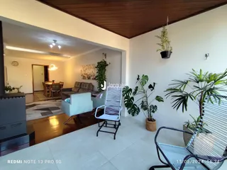 Sala de estar com piso de madeira e decoração de plantas.