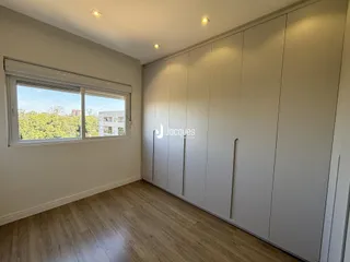 Quarto com armários embutidos e piso de madeira clara.