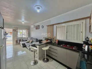 Sala de estar com cozinha integrada e piso de cerâmica em imóvel no Brasil.