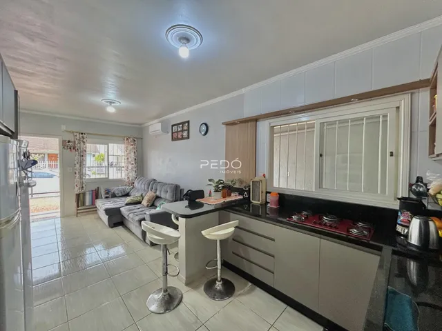 Sala de estar com cozinha integrada e piso de cerâmica em imóvel no Brasil.