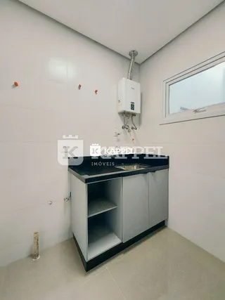 Mostrador de cozinha com pia e unidade de ar-condicionado na parede.