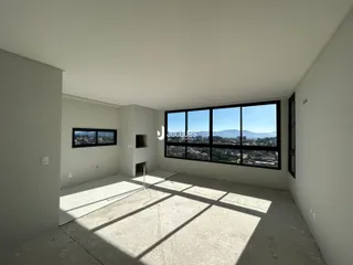 Ambiente interno de uma sala com piso de concreto e grande janela em Lajeado.