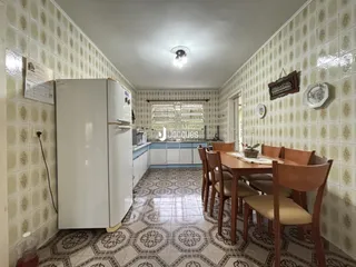 Uma sala de jantar com piso de cerâmica e armários brancos.