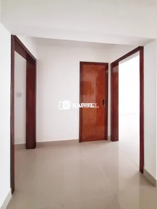 Hall de entrada com portas de madeira escura em um imóvel.