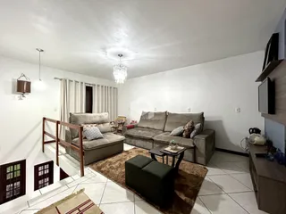 Sala de estar com sofá e piso de cerâmica em um imóvel no Brasil.