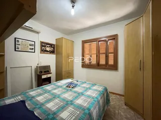 Quarto com armários de madeira e cama no interior de uma residência.