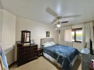 Quarto com cama e cômoda de madeira escura.