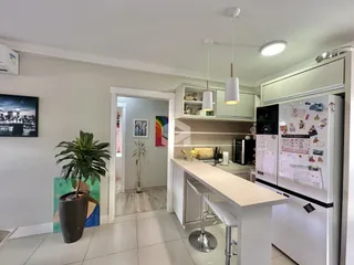 Cozinha moderna com armários brancos e ilha de bancada.