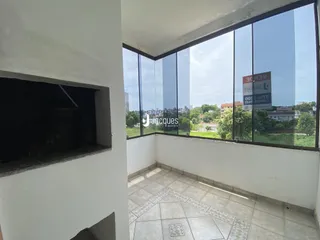Vista de um espaço com grandes janelas que oferece uma paisagem urbana.