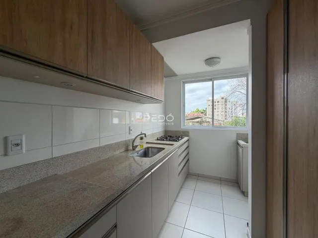 Cozinha moderna com armários de madeira e bancada clara.