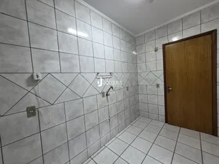 Banheiro com revestimento de azulejos brancos nas paredes e piso.