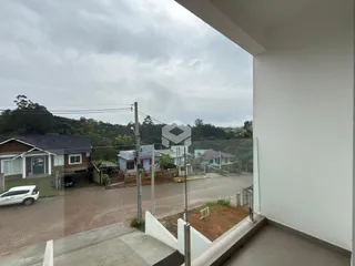 Vista externa de casas em Lajeado, Brasil, através de uma cerca de vidro.