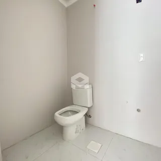 Foto de um banheiro interno com paredes brancas.