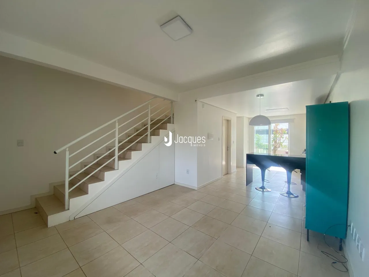 Hall com escada e piso de cerâmica em uma propriedade.