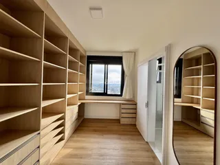 Interior de um corredor com estantes de madeira e piso de madeira.