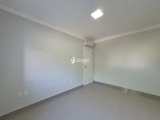 Corredor interno com paredes brancas e piso de cerâmica.