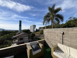 Vista de um terraço com vista para a paisagem e uma construção ao fundo.