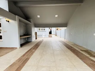 Corredor interno de uma residência com piso claro e detalhes em madeira.