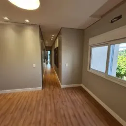 Ambiente interno com piso de madeira clara e teto liso.