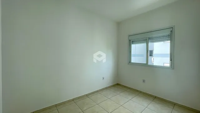 Vista interna de uma sala com paredes brancas e piso de cerâmica.