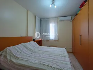 Quarto com cama e armários de madeira na sala.