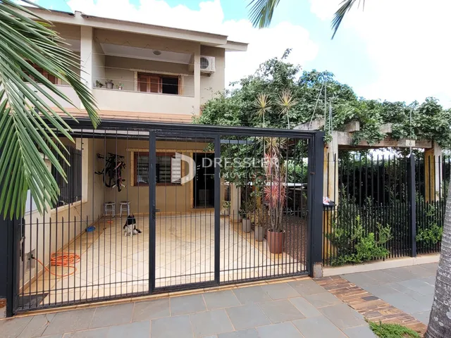 Fachada de uma residência com portão de ferro e pátio no Lajeado.