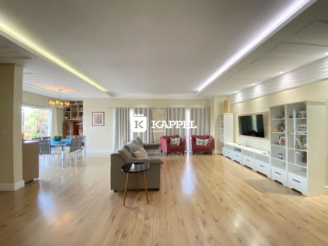 Sala de estar ampla com piso de madeira e móveis modernos.