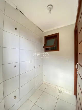 Corredor interno com piso de cerâmica e paredes brancas.