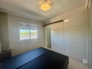 Quarto com cama e janela em uma sala de estar.