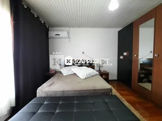 Quarto com cama e teto de painel branco.