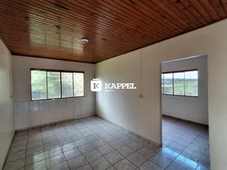 Sala de estar com piso de cerâmica e teto de madeira em um imóvel em Lajeado.