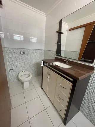 Banheiro com revestimento cerâmico nas paredes e piso.
