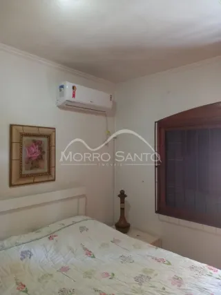 Quarto com cama e aparelho de ar-condicionado instalado na parede.
