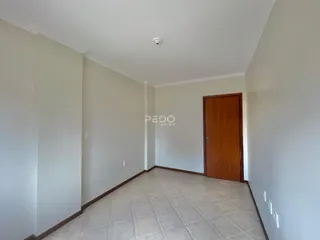 Hall de entrada com piso de cerâmica e porta de madeira.