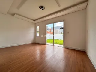 Sala de estar com piso de madeira clara e paredes brancas.