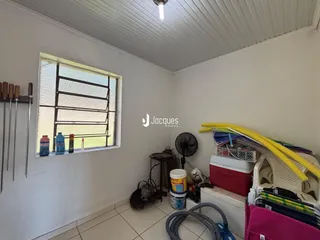 Interior de um cômodo com parede branca e piso de cerâmica.