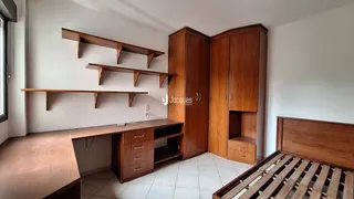 Quarto com armários e cabeceira de madeira.
