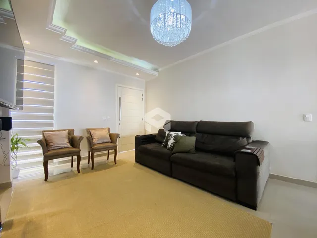 Foto de uma sala de estar com sofá e cadeiras.