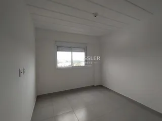 Vista interna de um cômodo com paredes brancas e piso de cerâmica.