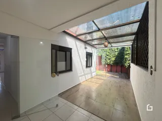 Vista interna de um ambiente com piso de cerâmica e porta de vidro que se abre para o exterior.