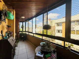 Hall da casa com grande janela de vista para a cidade.