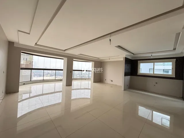 A sala de estar apresenta um piso claro e grandes janelas.