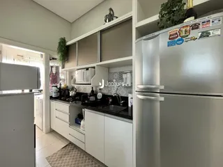 Foto de uma cozinha moderna com armários brancos e bancadas escuras.