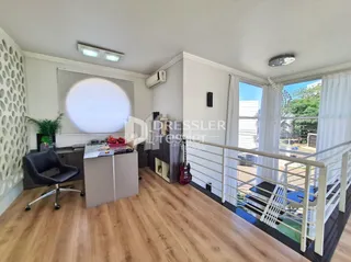 Sala de estar com piso de madeira e acesso a uma varanda.