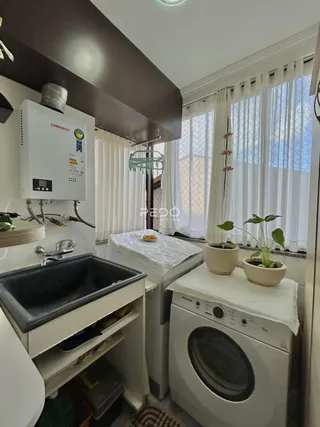 Foto de uma área de cozinha com máquina de lavar e janela.