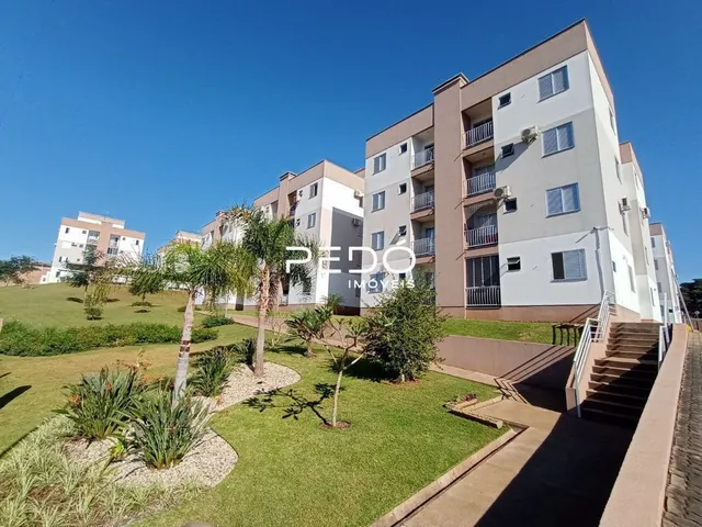 Vista externa de um prédio residencial com jardim e paisagismo.