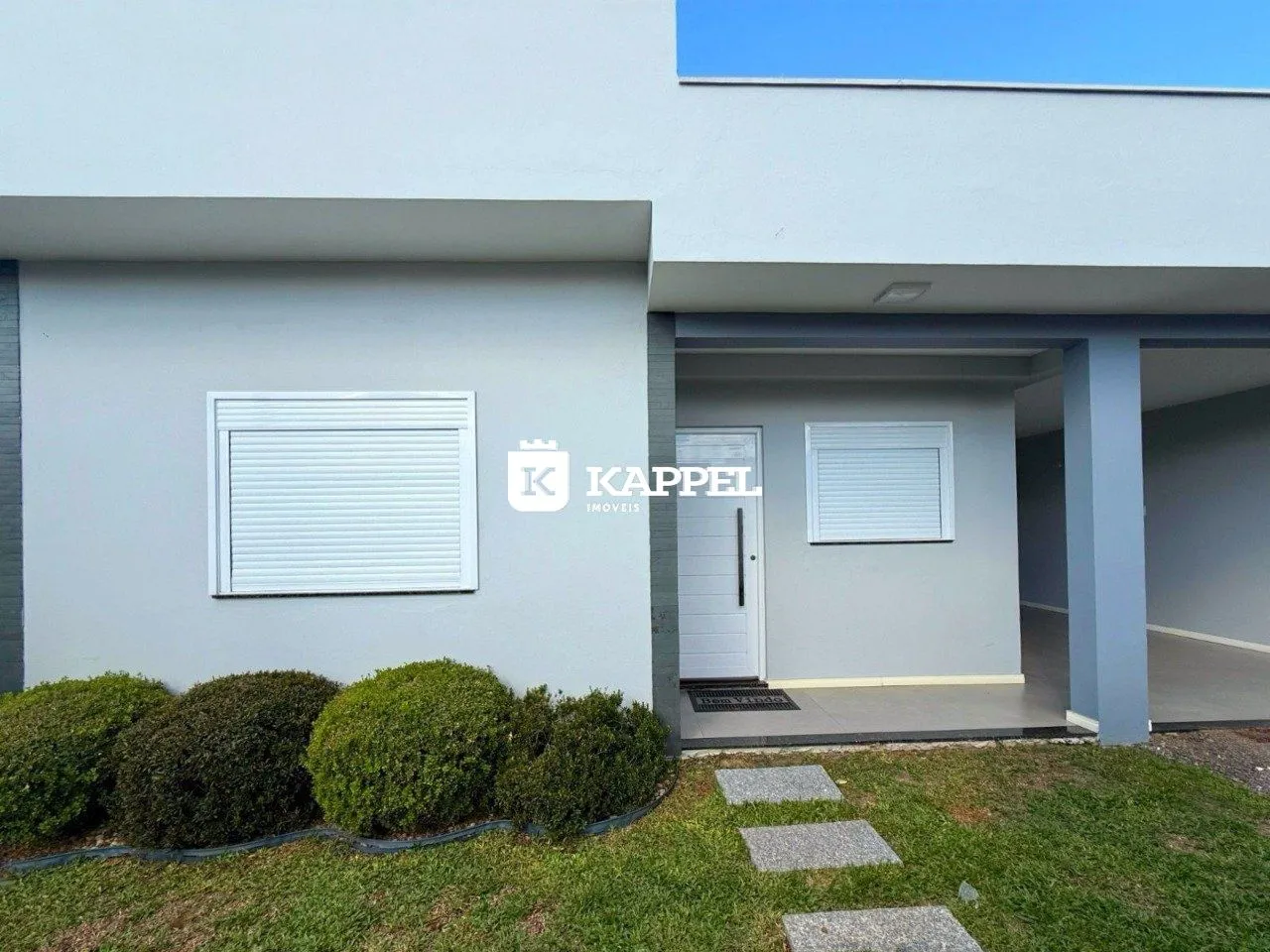 Fachada moderna de uma residência em Lajeado, Brasil, com jardim frontal.