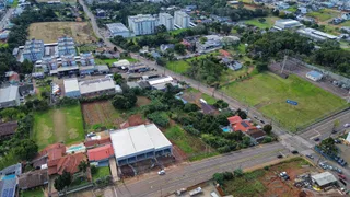 Vista aérea de uma propriedade rural com campos e infraestrutura de estrada.